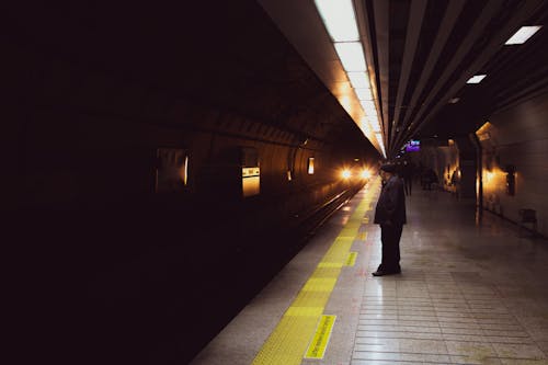 Free Man in Black Jacket Standing Behind the Yellow Line while Waiting for the Train  Stock Photo