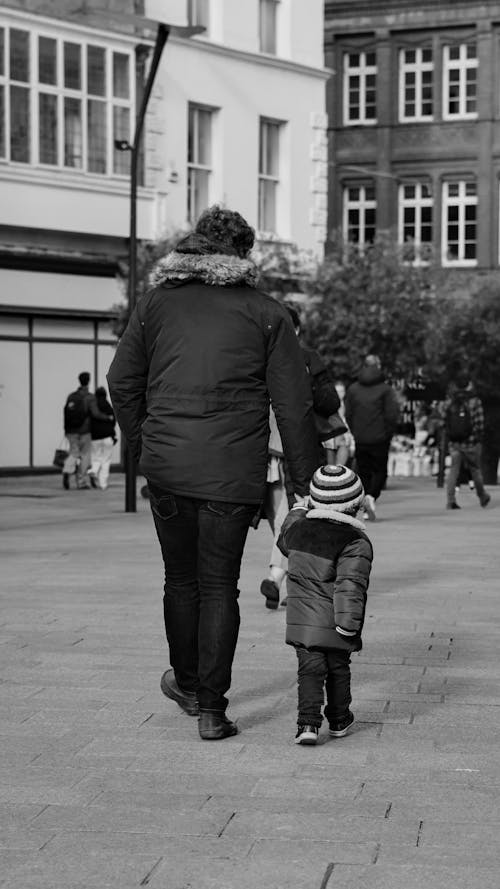 Free Back View of a Man Walking with his Son Stock Photo
