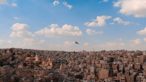 Free Stunning panoramic view of Amman cityscape under a clear blue sky with the Jordanian flag visible. Stock Photo