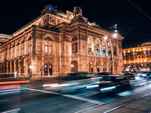 Free Stunning view of Vienna State Opera illuminated against the night sky with motion blur from passing cars. Stock Photo