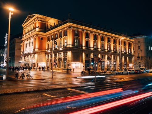 Free Illuminated historic concert hall in Vienna's city center captured at night with dynamic street lights. Stock Photo