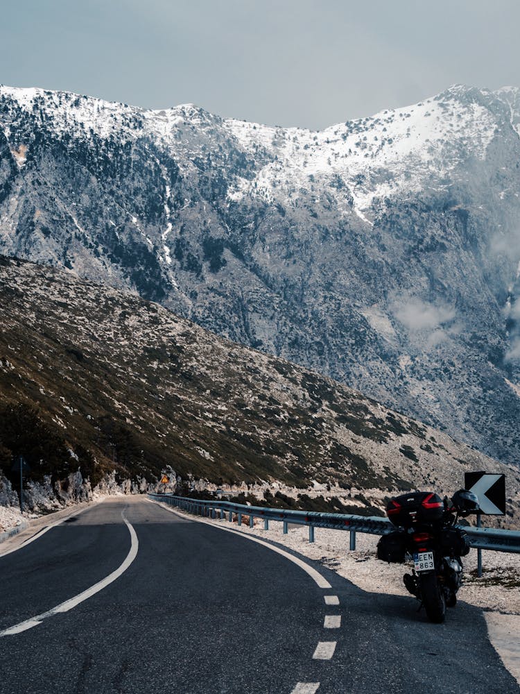 Black Motorcycle Parked Near The Mountain Road