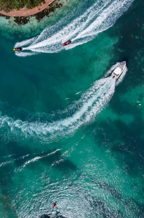 Free High-angle view of speed boats creating trails on the turquoise waters of Cancun, Mexico. Stock Photo