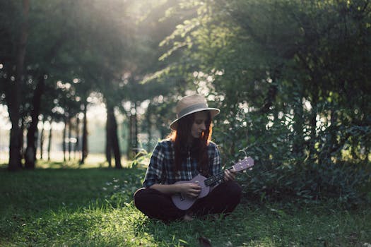 一名妇女坐在阳光明媚的公园树下，弹着尤克里里，享受着平静的时光