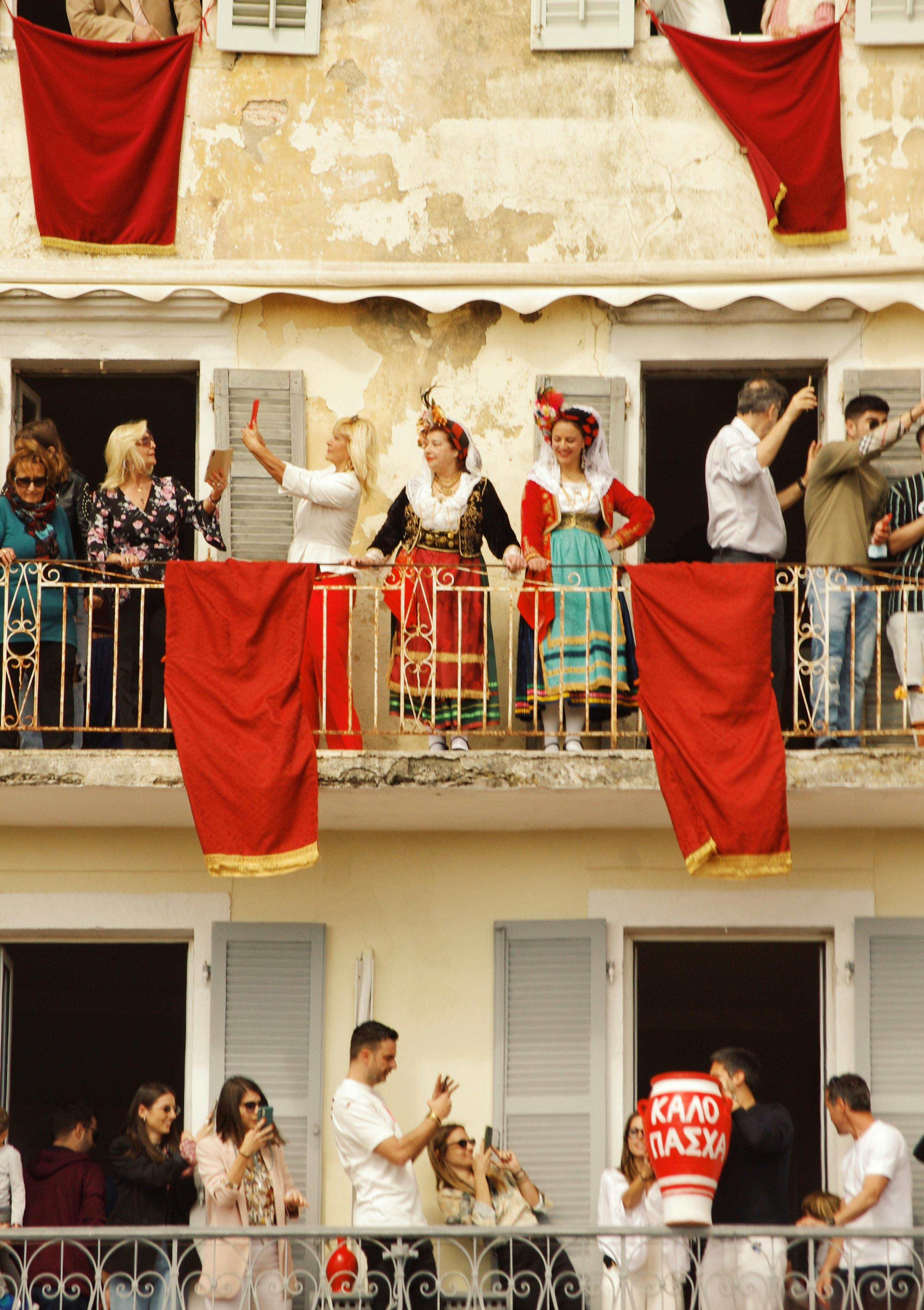 People in traditional clothing celebrating Easter on a balcony in Corfu, Greece.