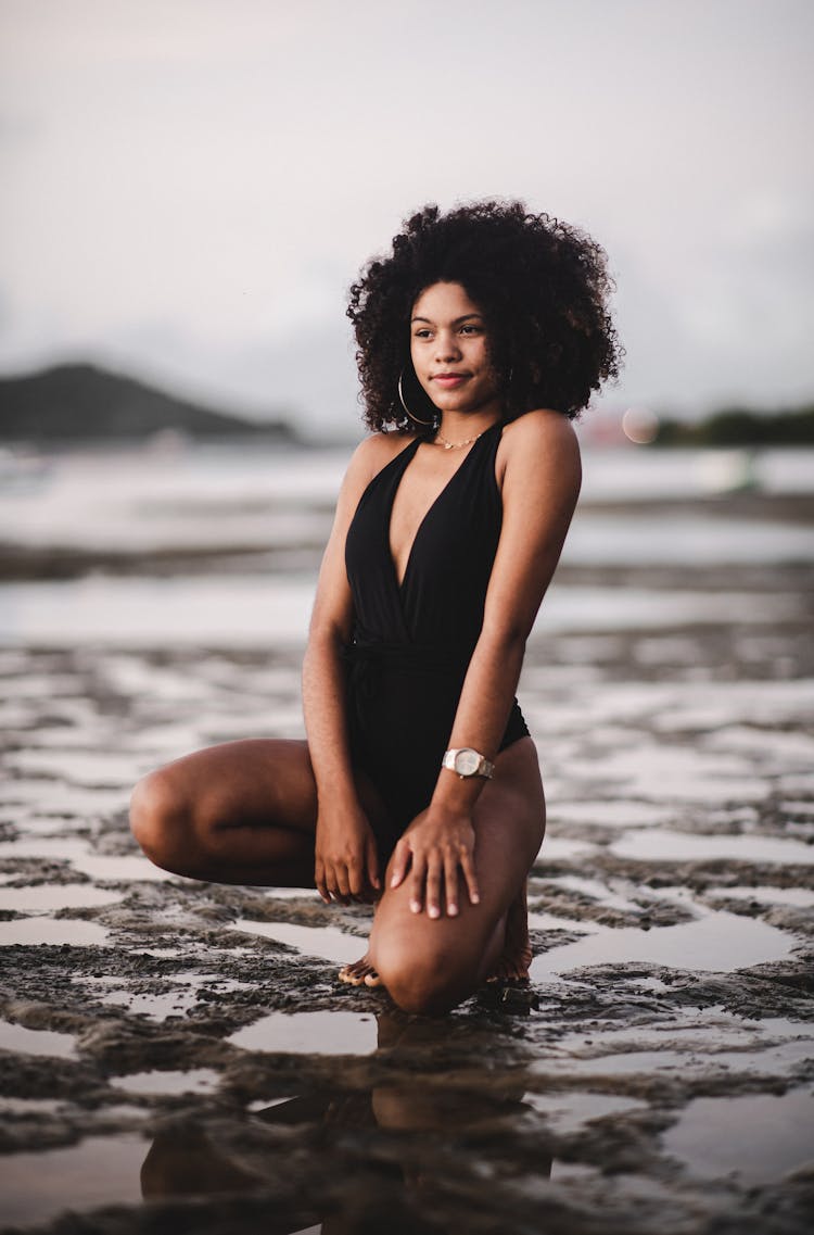 Woman In Swimsuit Kneeling In Wetland