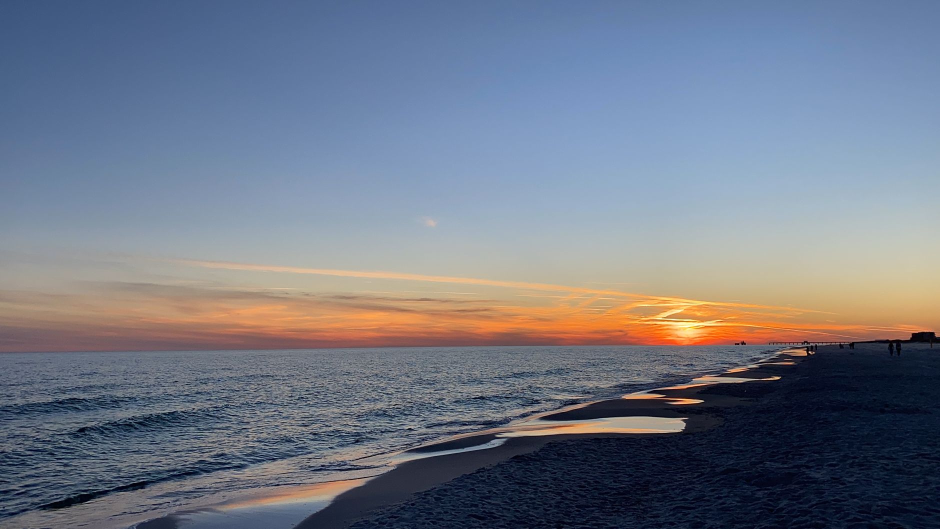 Breathtaking sunset view over the Gulf Shores beach with gentle waves and colorful sky.