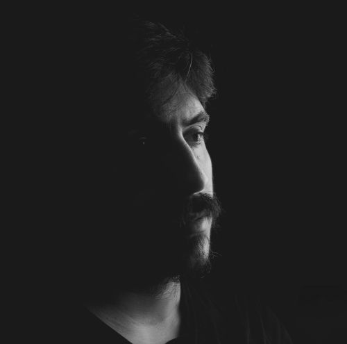 Free Intense black and white portrait of a man highlighting his mustache and shadowed face. Stock Photo