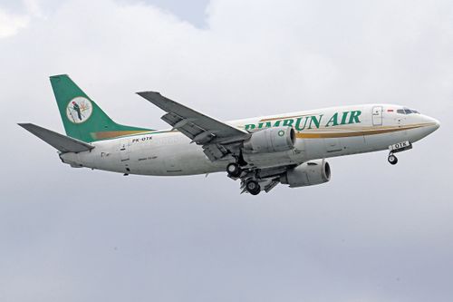 Free Rimbun Air aircraft soaring high against a backdrop of clouds. Stock Photo