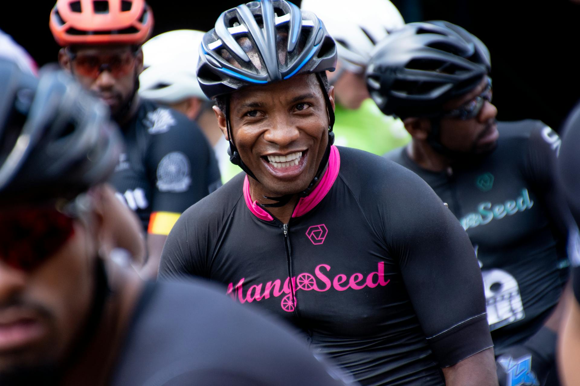 Energetic cyclists in helmets at a race, showcasing enthusiasm and teamwork.