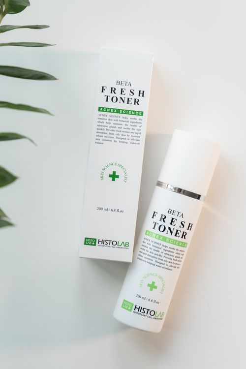 Free High-quality image of HISTOLAB Beta Fresh Toner with packaging, styled on white surface with leaves. Stock Photo