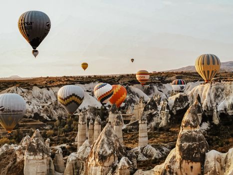 Vibrant hot air balloons soar over the stunning rock formations of Cappadocia at sunrise.