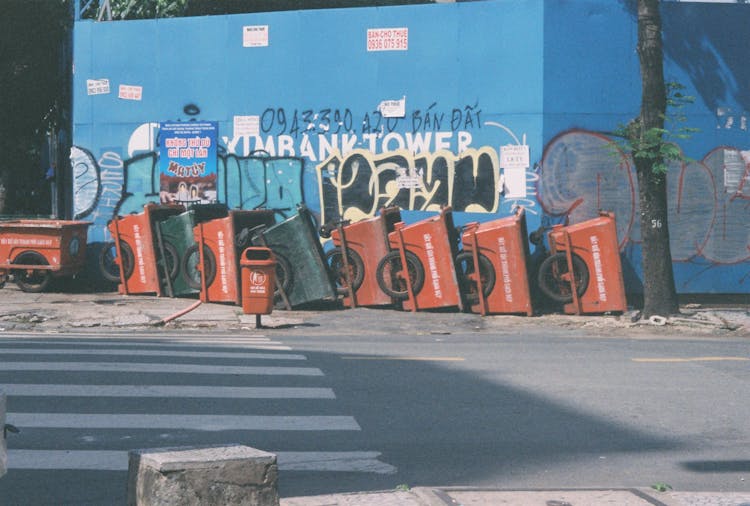 Metal Trolley Bins Near A Blue Wall