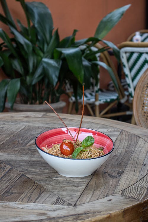 Free Pasta Decorated with Fresh Basil and Tomato Served in Bowl Stock Photo