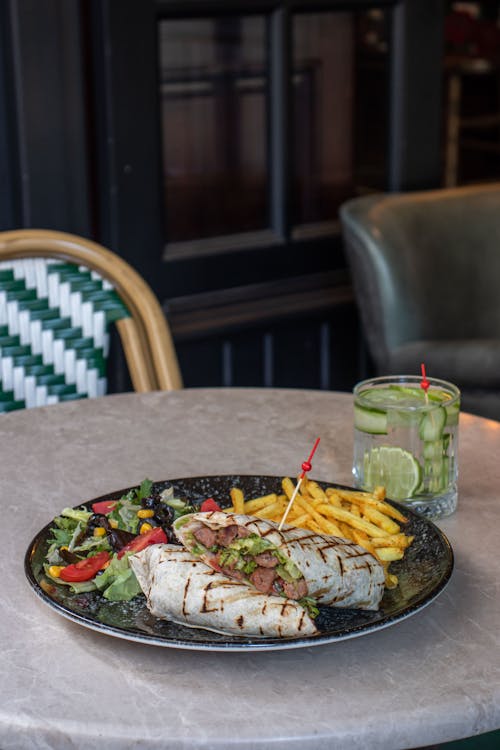 Food on a Ceramic Plate Near a Glass of Drink