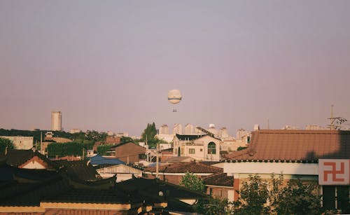 Darmowe zdjęcie z galerii z balon na gorące powietrze, budynki, drzewa