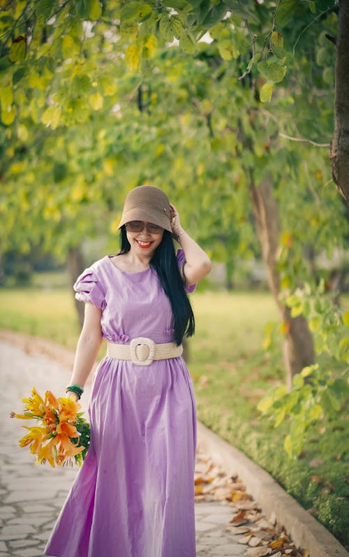 Woman Wearing Purple Dress Holding Yellow Flowers