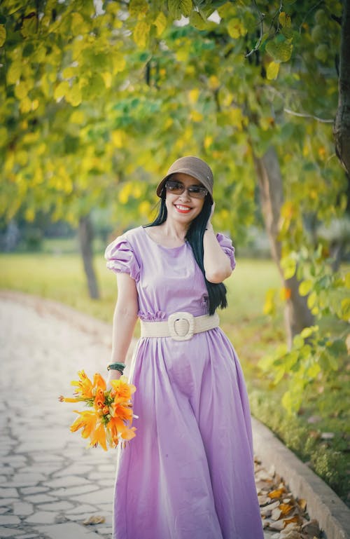 Woman in Purple Dress Holding Flowers