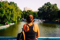 夏天，一名女子在绿意盎然的公园河边享受宁静的时刻