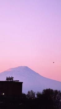 Peaceful dawn view of Mount Ararat with a clear Yerevan skyline. Iconic silhouette at sunrise.