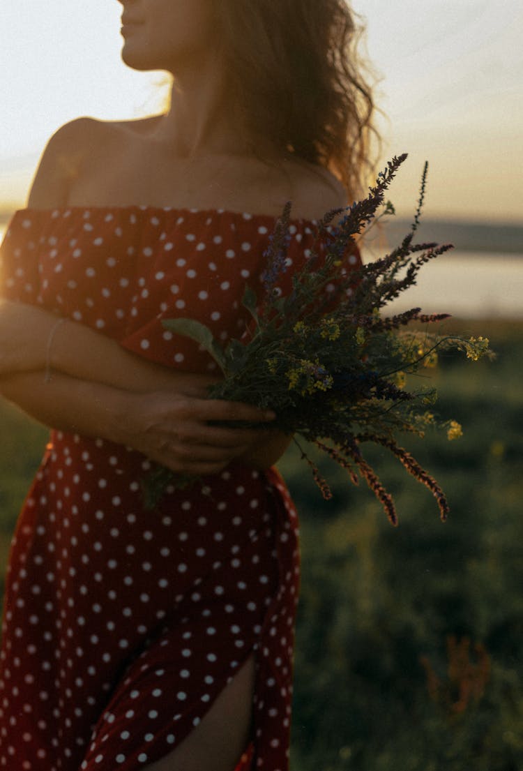 Woman In Red Summer Dress Standing With Bunch Of Wild Flowers