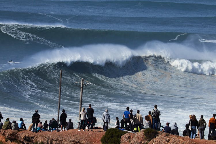 People On Brown Plateau Watching Big Waves