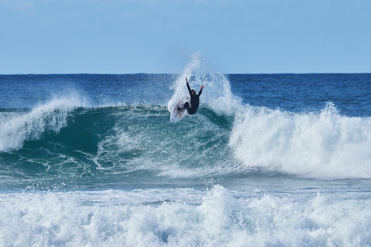 Surfer Jumping On Sea Wave