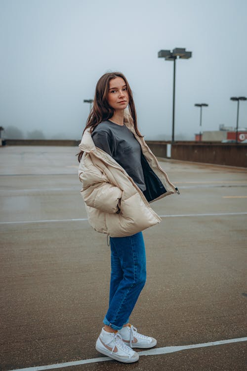 A Woman in Denim Jeans Standing on the Street