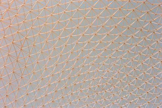A detailed view of a geometric metal framework ceiling with triangular patterns.