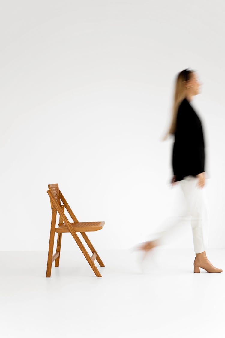 Woman Walking Near A Wooden Chair