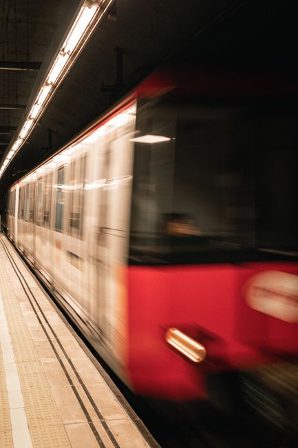 Blurred motion of a metro train speeding through an underground station.
