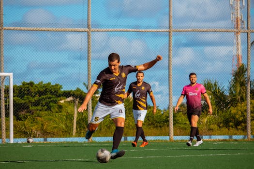 Athletes playing soccer in an outdoor field showcasing teamwork and agility.