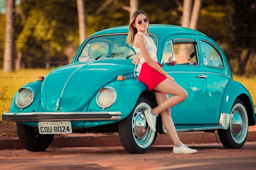 Free Beautiful Woman Leaning on a Vintage Car Stock Photo