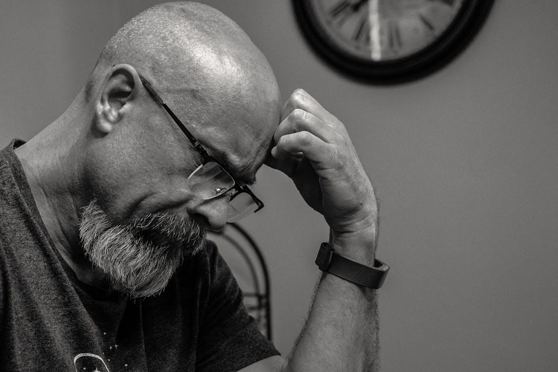 Free Grayscale Photo of Man Thinking in Front of Analog Wall Clock Stock Photo