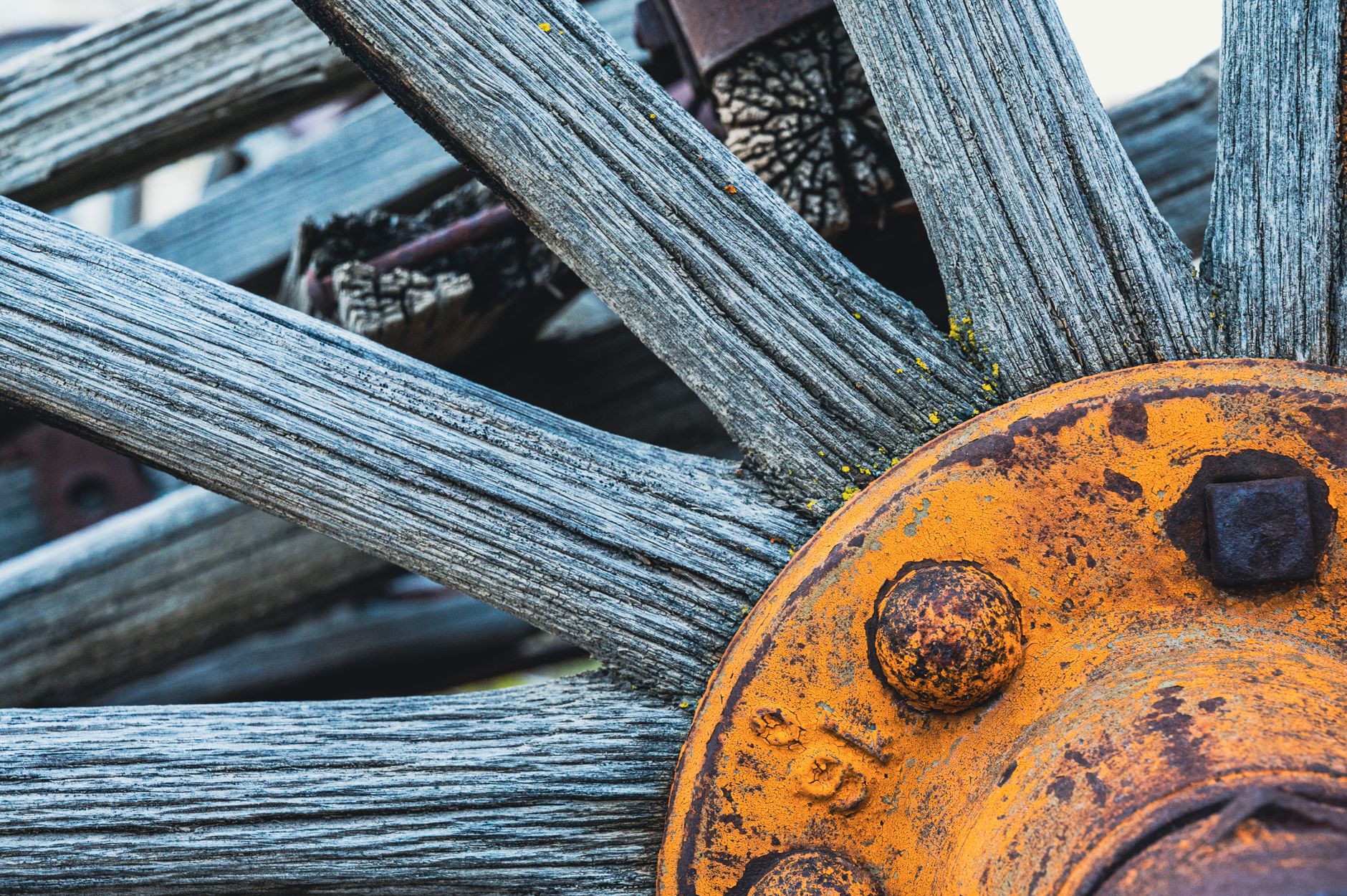 Detailed image of a weathered wooden wheel with rusty metal components highlighting texture and age.