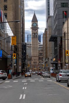 View of Toronto's Old City Hall and bustling street scene with cars and pedestrians.