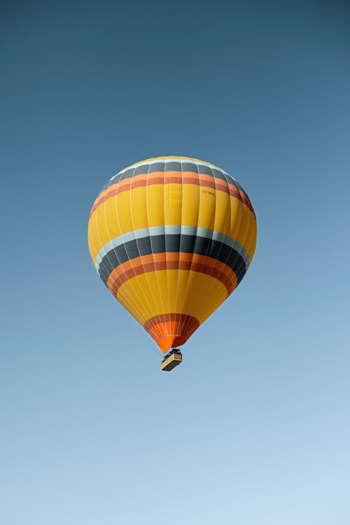 Free Colourful Balloon with Gondola in Clear Blue Sky Stock Photo