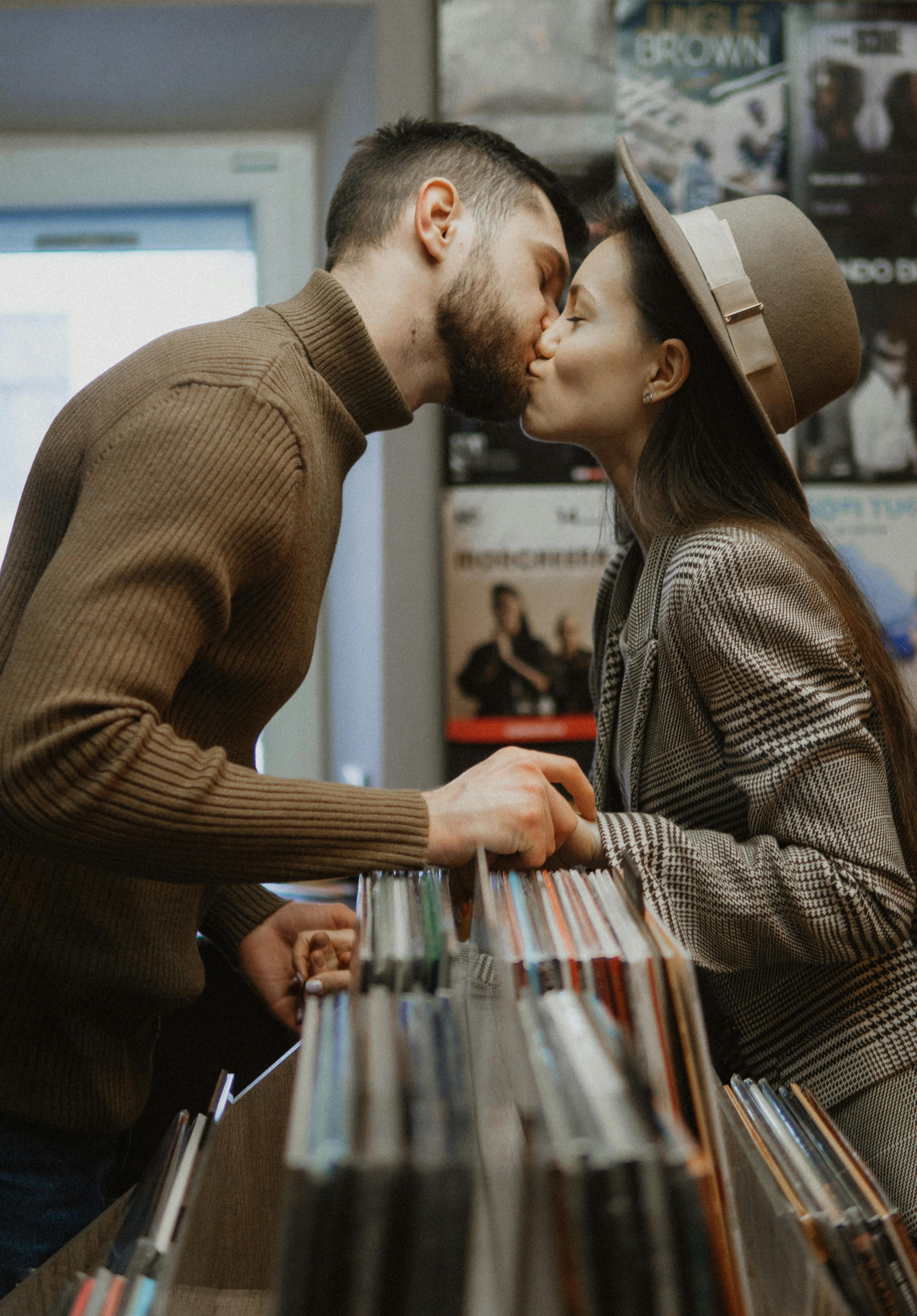 couple kissing in music store over vinyl records shelf
