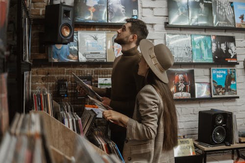 Man and Woman Looking at Vintage Music Albums in a Store