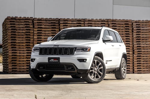 Free White Jeep Cherokee Suv Near Stacked Brown Pallet Boards Stock Photo