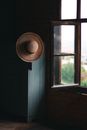 Straw Hat Hanging by Window in Hut