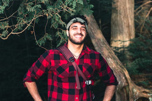 Man in Red and Black Plaid Shirt Standing Near Tree