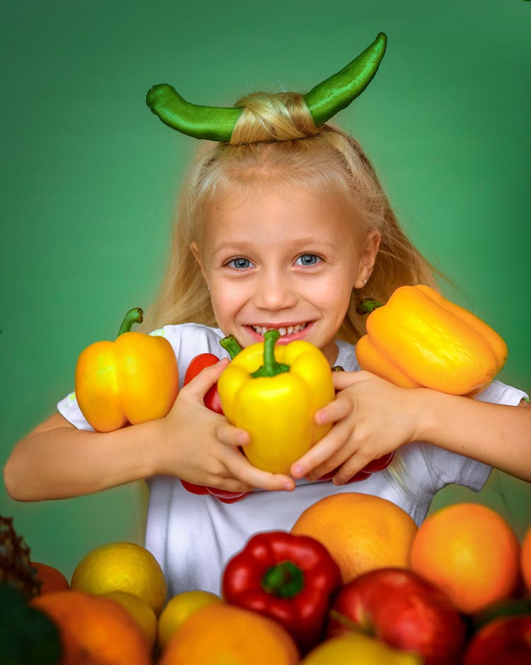 Photo Of A Kid Holding Bell Peppers