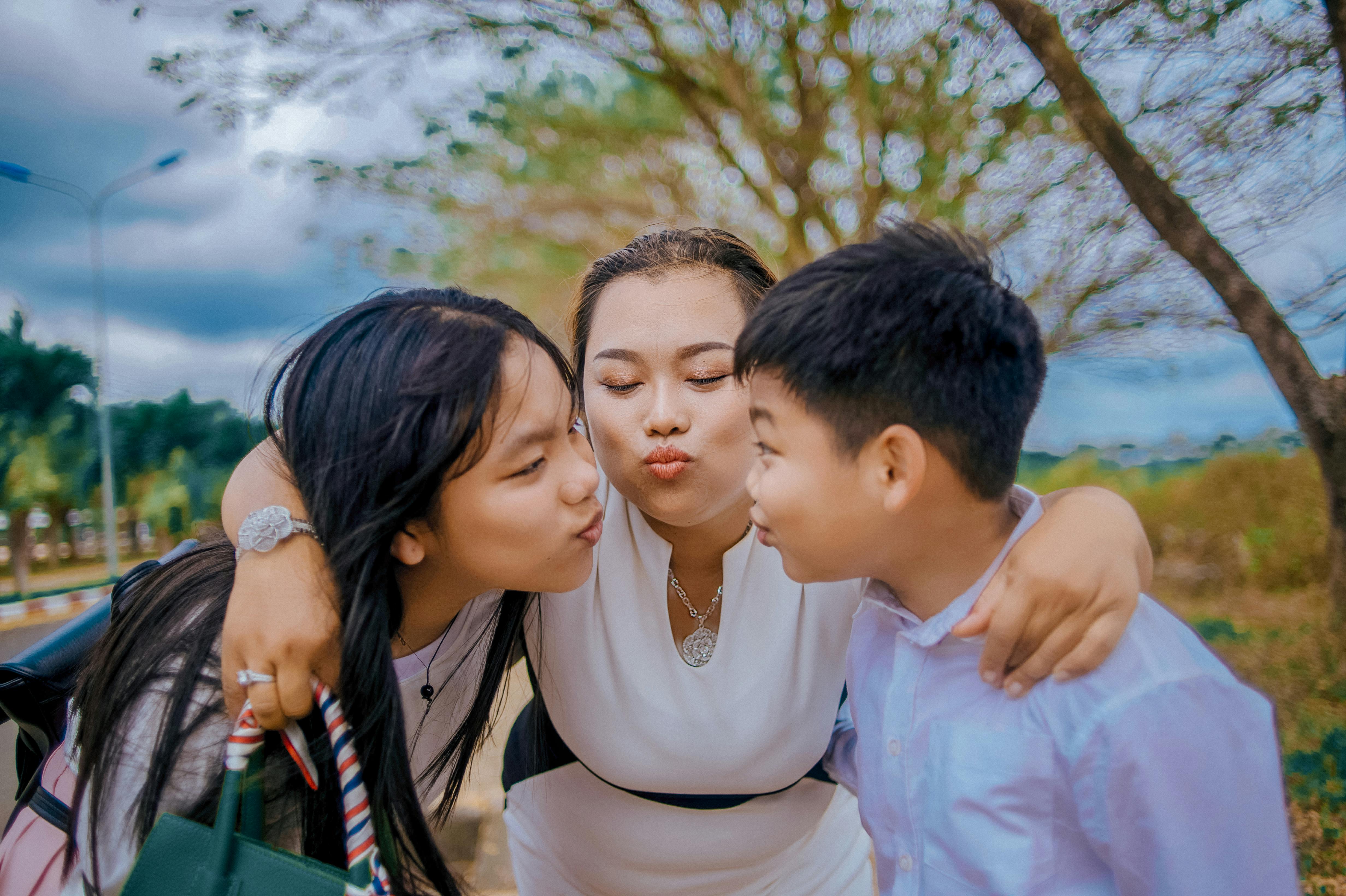 木の近くでキスする3人 無料の写真素材