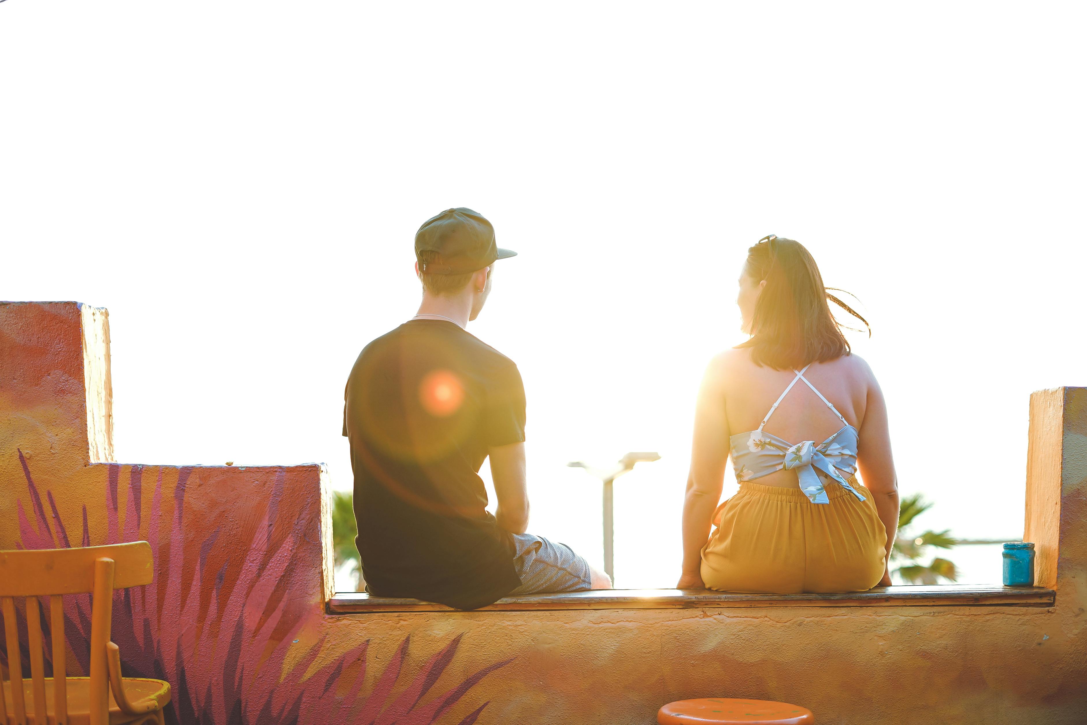 Man And Woman Sitting On Ledge Free Stock Photo<script async src=