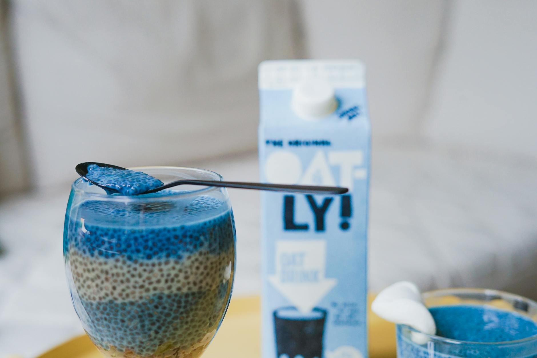 Delicious blue chia pudding served in glass with oat milk for a beautiful, healthy snack.