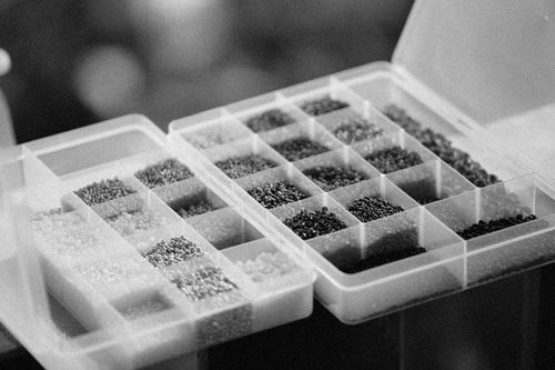 Free A grayscale close-up image of assorted beads organized in a plastic case, showcasing detailed craftsmanship. Stock Photo