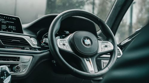 Free Detailed view of a BMW car interior highlighting the steering wheel and dashboard. Stock Photo
