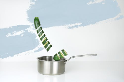 Gray Stainless Steel Sauce Pan and Green Cucumber Illustration