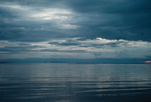 Free Calm ocean scene with a cloudy sky during twilight, evoking tranquility and reflection. Stock Photo